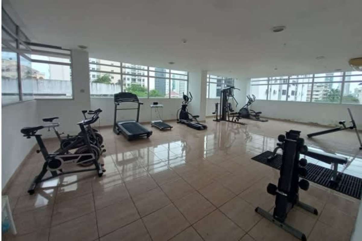 Modern fitness center with equipment and large windows in PH El Cangrejo Panama City