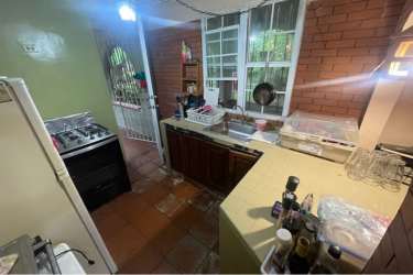 Rustic traditional kitchen with brick wall, windows and door in Punta Barco Village Panama