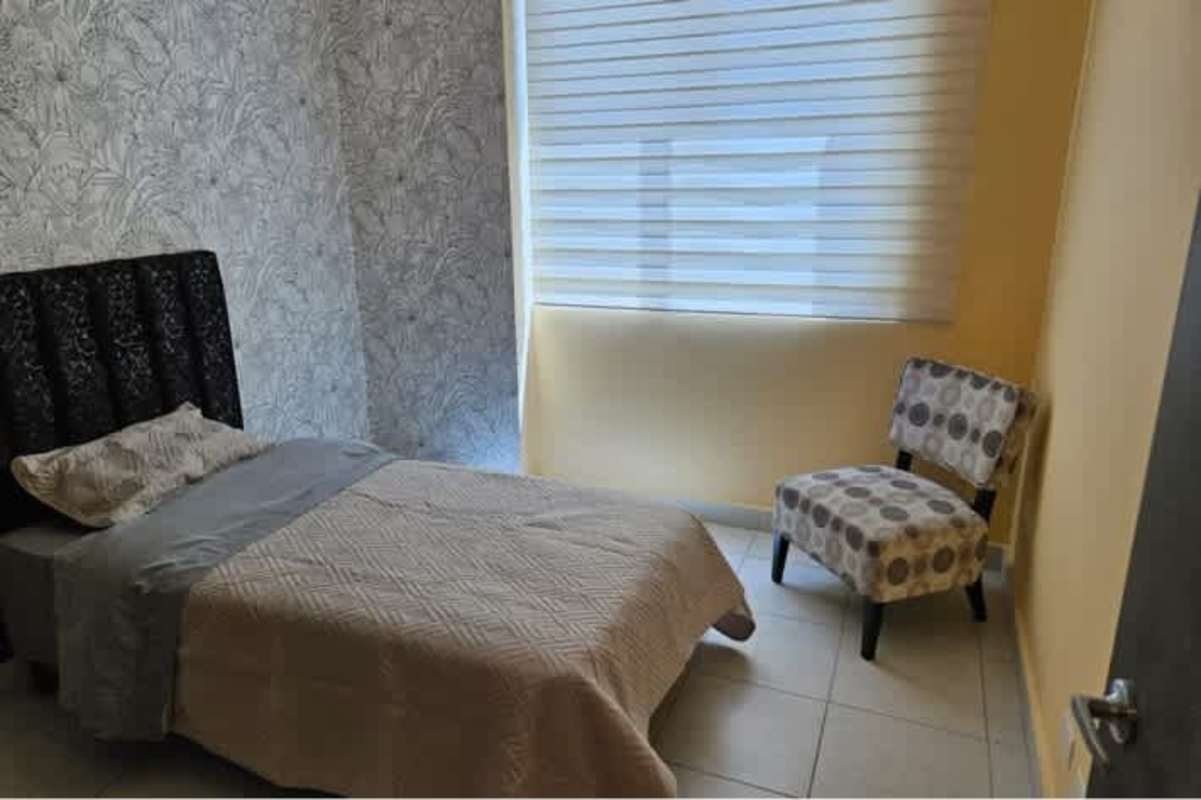 Small bedroom with builtin closets, orange chair, blinds in PH Miró Panama