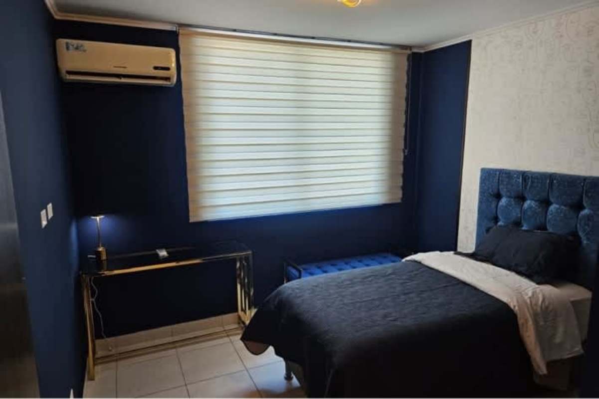 Bedroom with blue navy wall, gold desk, blinds, tufted bed PH Miró Panama