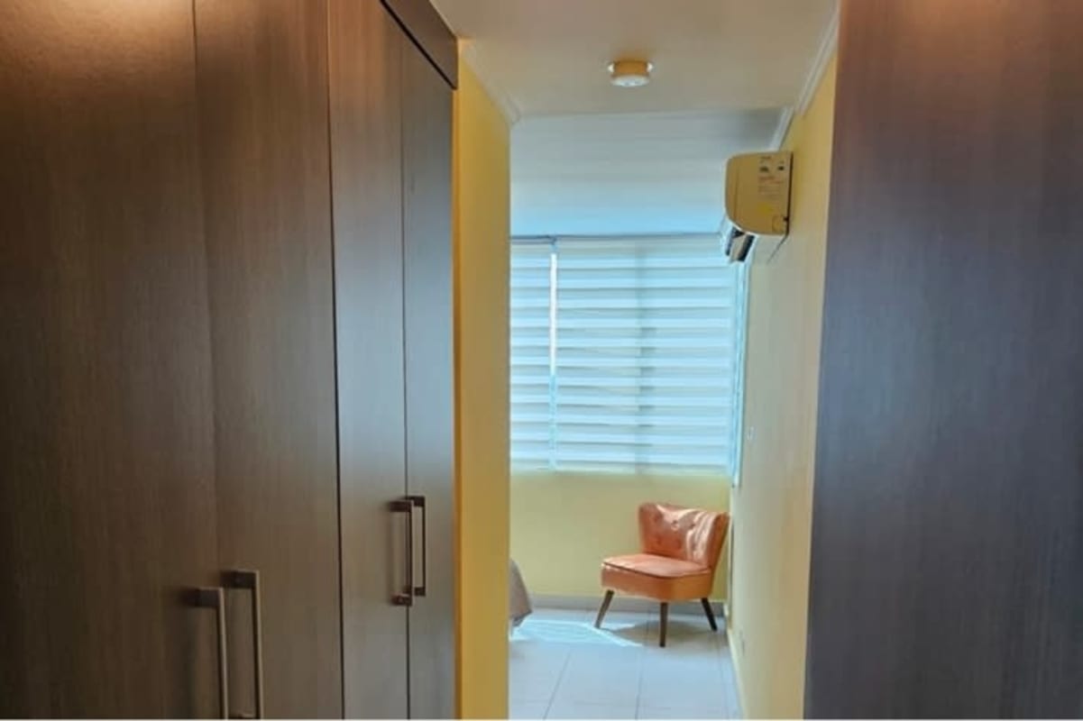 Bedroom entry hall featuring wood closets and accent seating in PH Miró Panama
