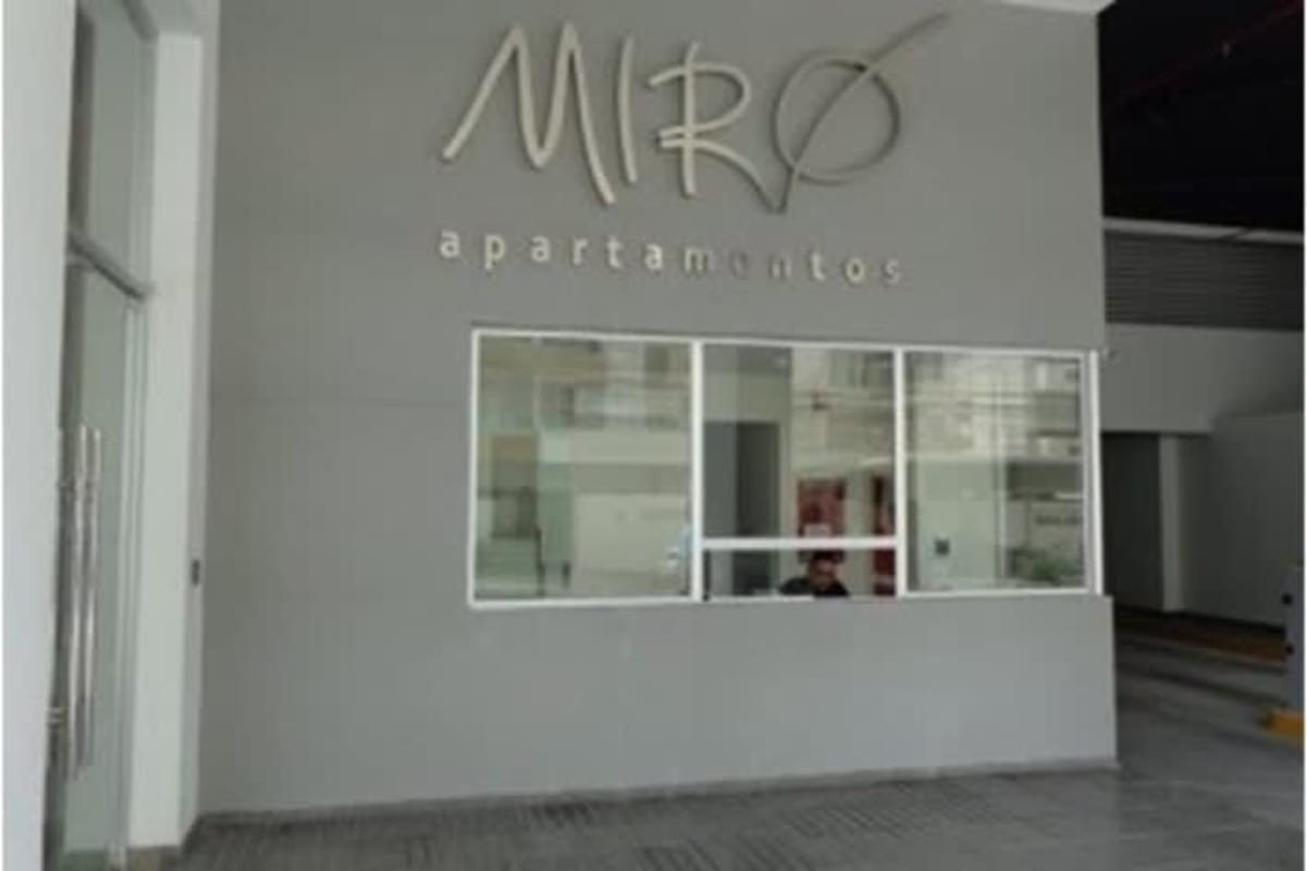 Spacious open living and dining with green accent wall and wall-mounted TV at PH Miró