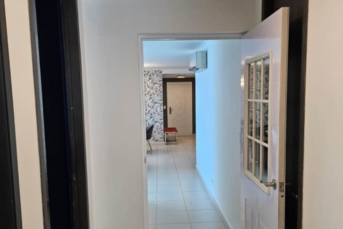 White tile hallway with black frames leading to living space in PH Miró Panama