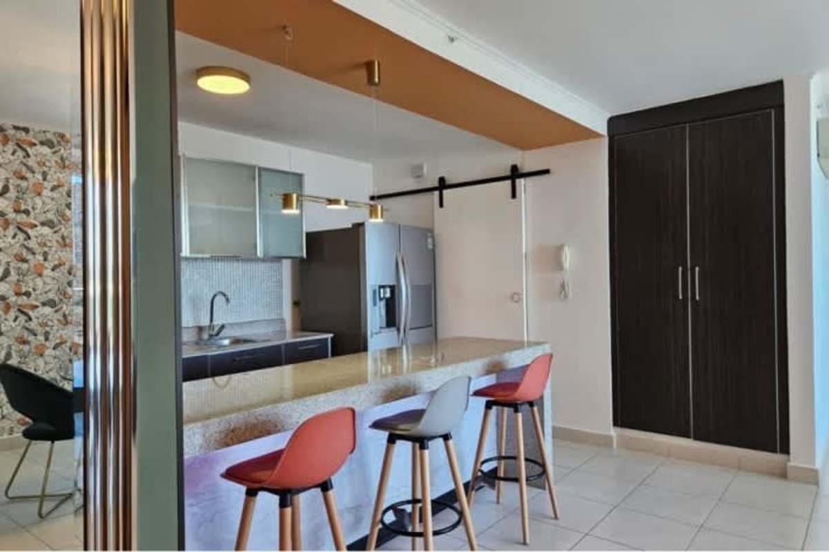 Kitchen with granite island, colorful stools, stainless appliances in PH Miró Panama