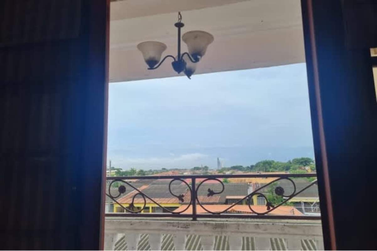 Interior of a room with balcony access, decorative iron railing, and chandelier at Altos de Las Praderas San Miguelito Panama
