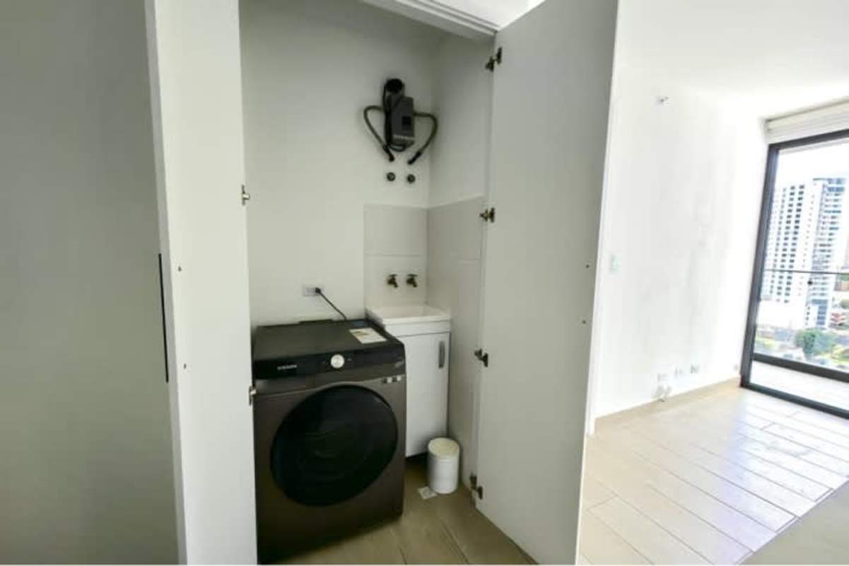 Modern bathroom with glass-enclosed shower, black fixtures, minimalist design in Living73 Panama