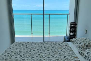 Bedroom with floor-to-ceiling sliding doors leading to balcony and ocean view in PH Royal Palm Panama
