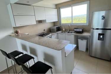 Modern white kitchen with granite counters, stainless appliances, bar seating at PH Royal Palm