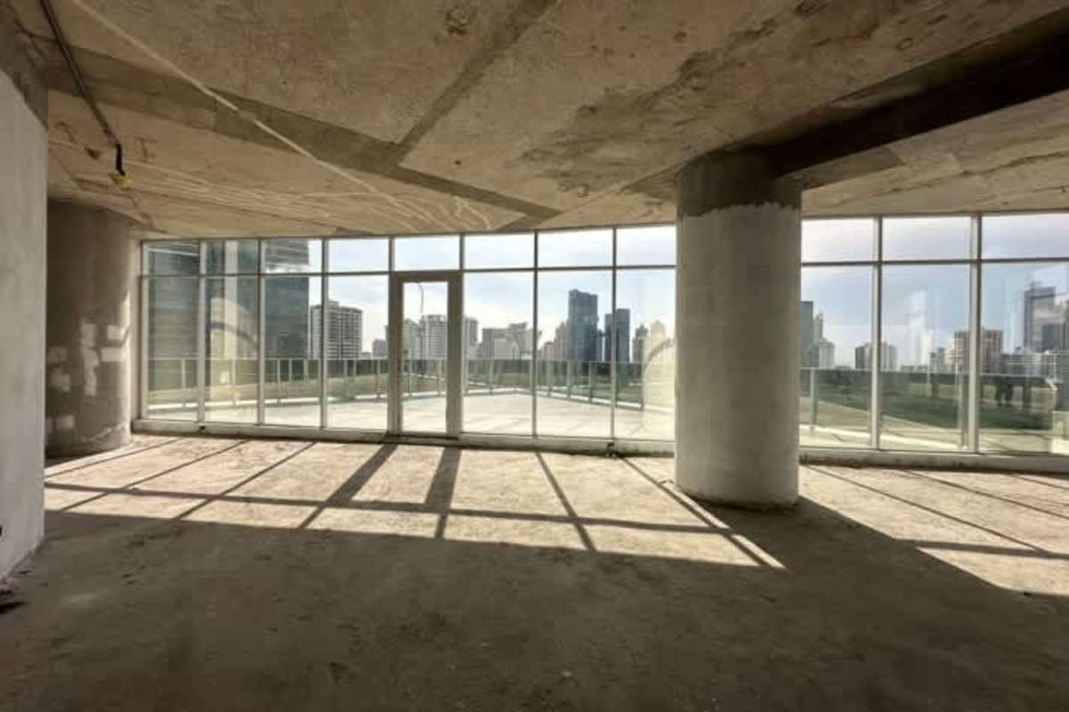 Gray shell state office space with floor-to-ceiling windows exposed concrete FF Tower Panama City
