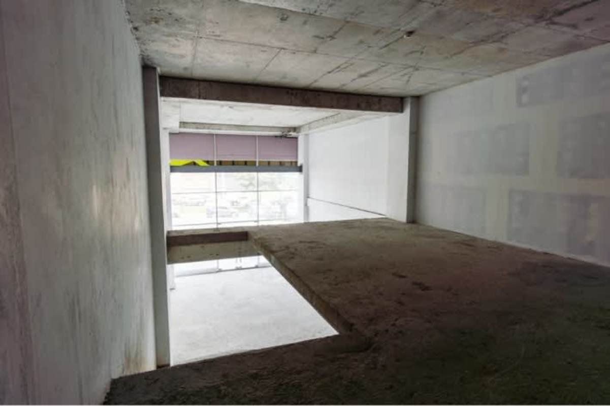 Raw commercial interior space with large windows and exposed concrete for retail or office Betania Panama