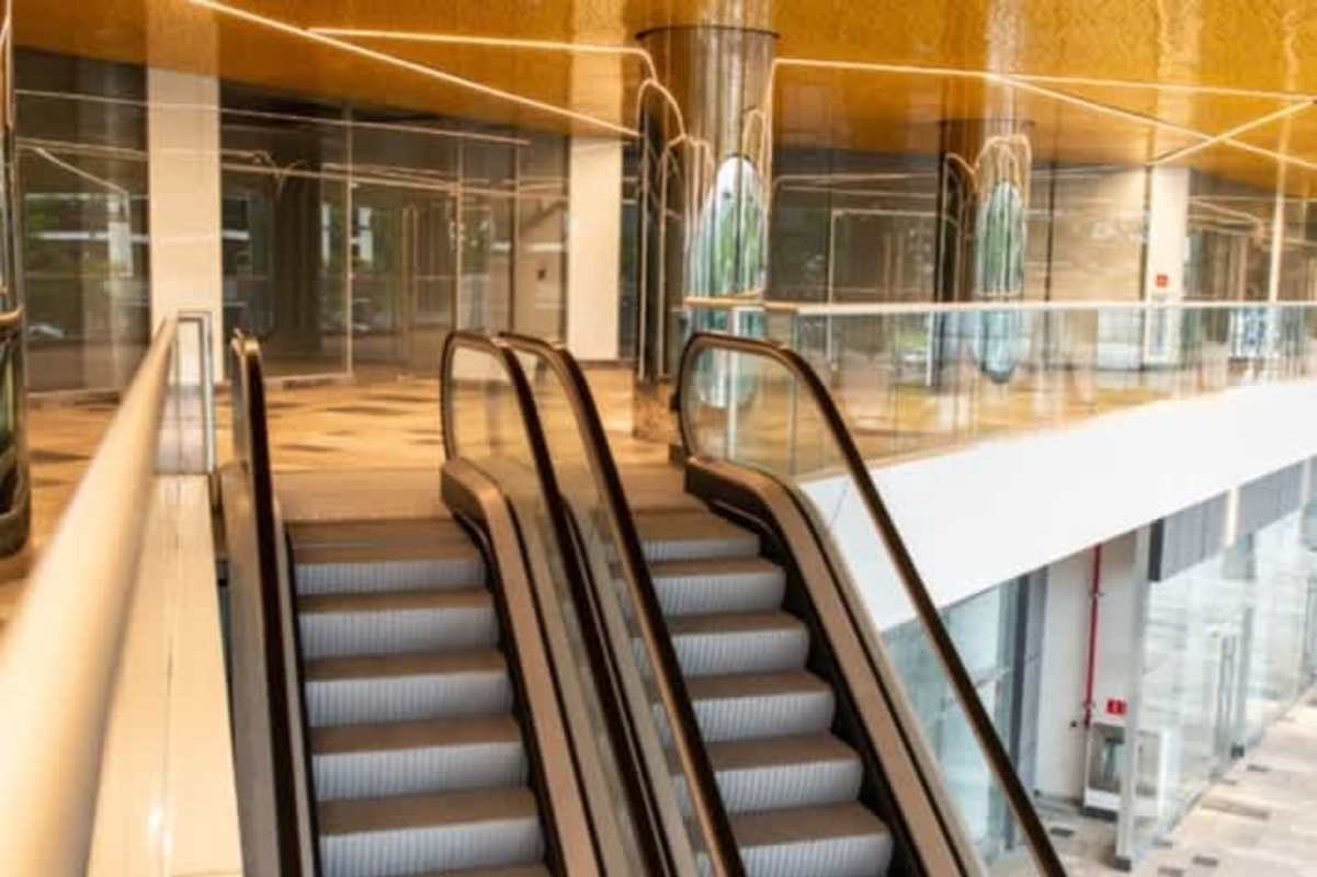 Lobby with escalators, glass railings and mirrored columns inside commercial plaza Betania Panama