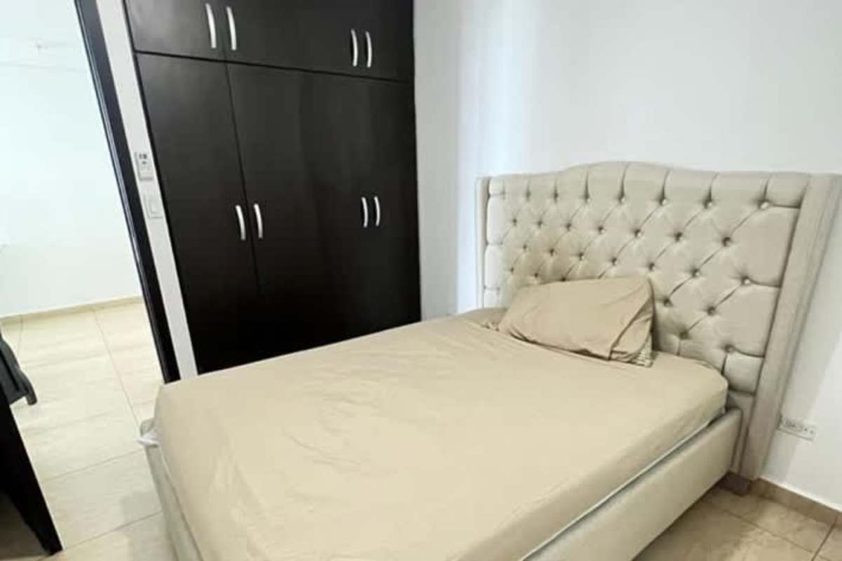 Bedroom with tufted beige bed, roller blinds, AC and minimalist decor PH Torres de Carrasquilla San Francisco Panama