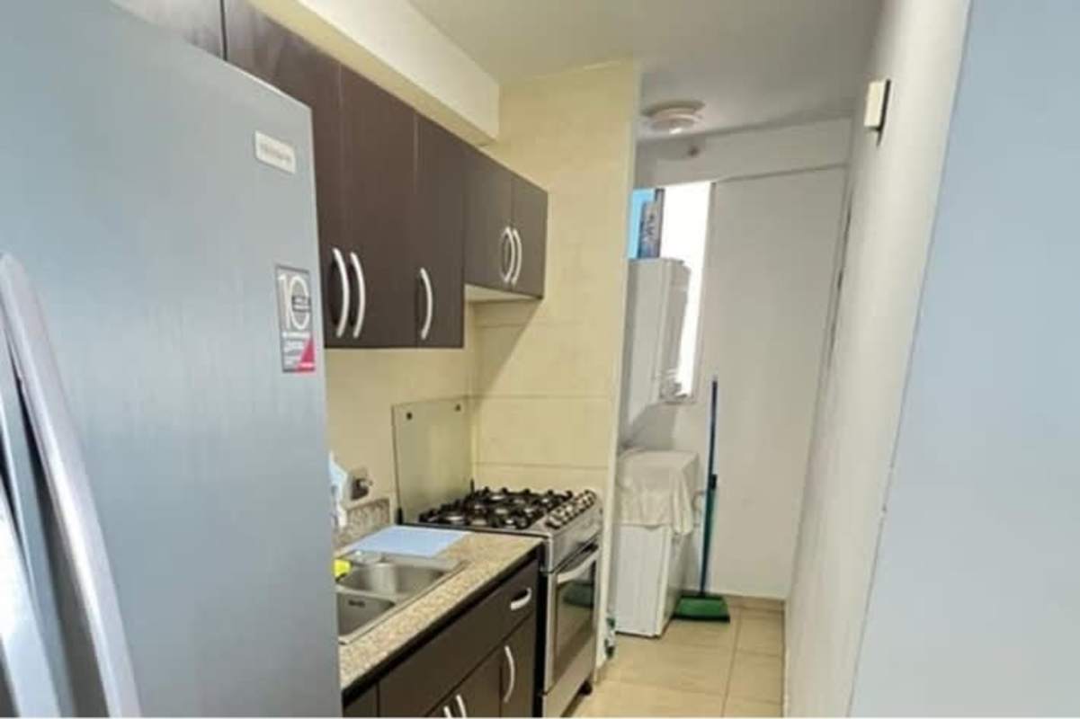 Compact modern kitchen with brown cabinets, granite counters, stove, fridge PH Torres de Carrasquilla Panama