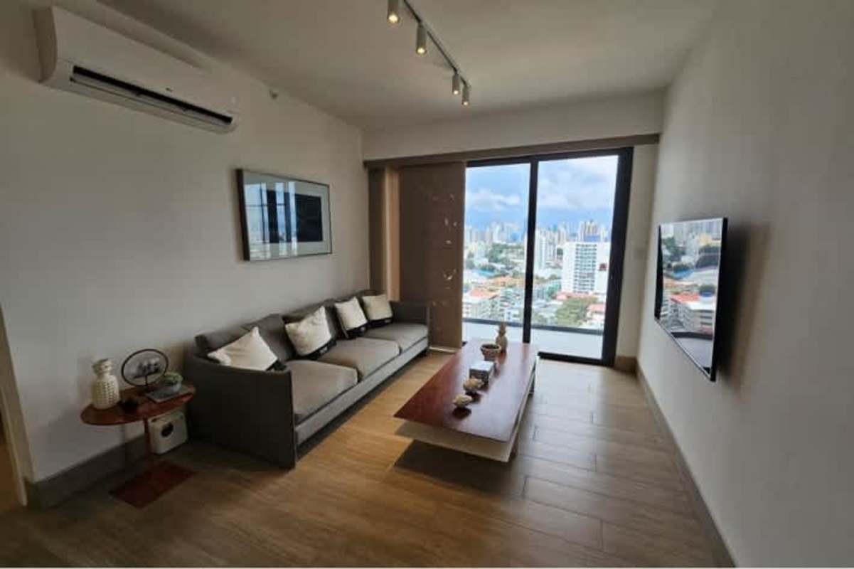 Living room with large windows, AC, wood floors, mounted TV in PH Hato Pintado Heights