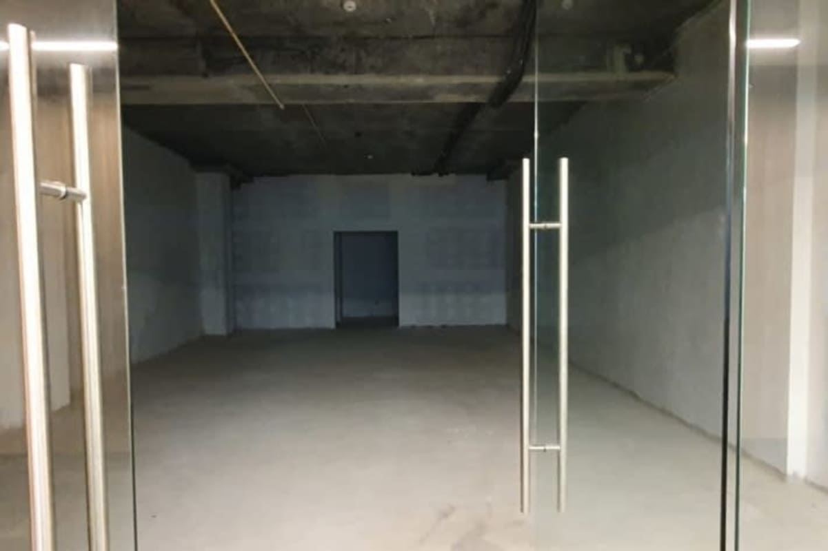 Raw commercial shell with glass double door and concrete ceiling at El Dorado Plaza Panama