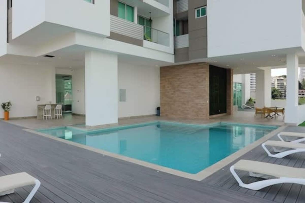 Modern infinity pool with wooden deck, lounge chairs and social seating at PH Altamira Residences Panama City