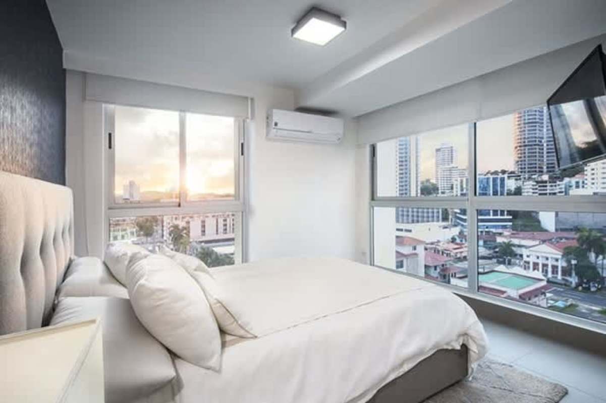 Comfortable bedroom with large windows featuring city skyline at PH Altamira Residences Avenida Balboa Panama