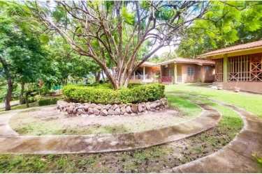 Expansive fenced yard with tropical plants and mature trees in Coronado Beach House Panama