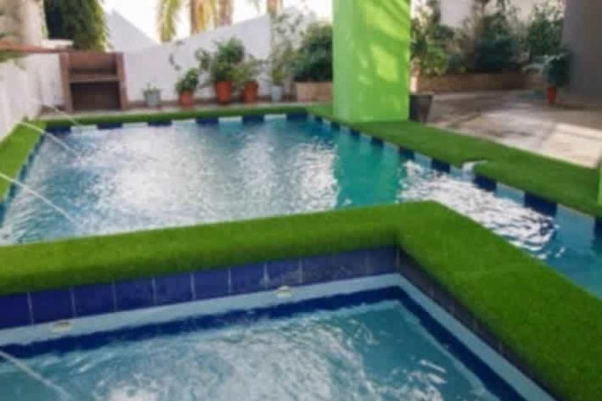 Modern swimming pool with jacuzzi, artificial grass and BBQ area at PH Sky Point in Panama City