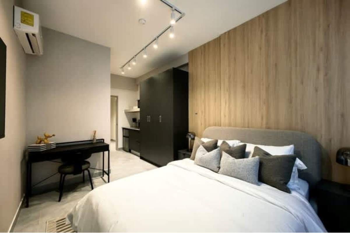 Spacious bedroom with window blinds, accent wall, headboard PH The Park El Cangrejo Panama City