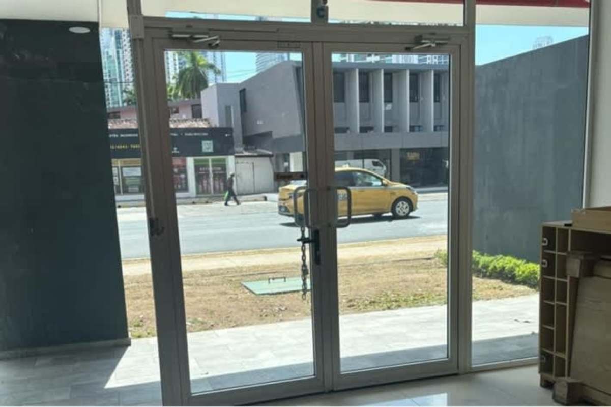 Glass facade entrance with reflective panels and double doors at Signature Point Plaza