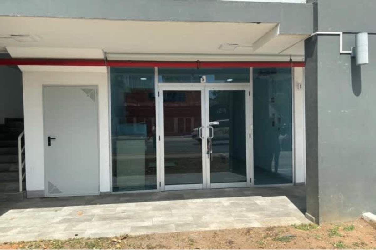 Modern commercial sidewalk with glass doors and signage at Signature Point Plaza Panama