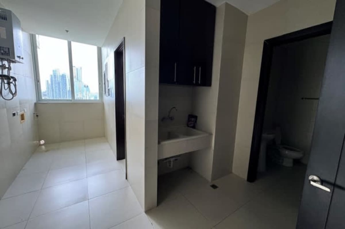 Fully equipped luxury granite kitchen with dark wood cabinets and stainless appliances at Punta Paitilla high-rise apartment Panama