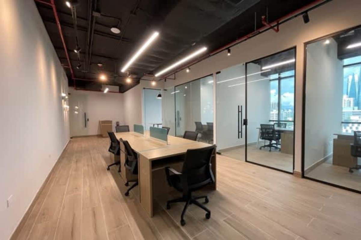 Modern office with open workstations glass walls exposed ceilings and city view in PH F&F Tower Obarrio Panama City