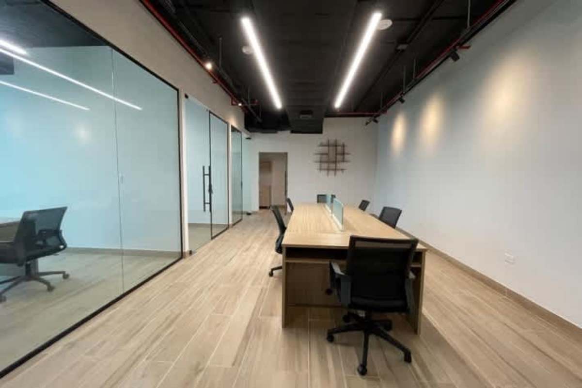 Modern minimalist meeting room with glass walls wood floors and large conference table in PH F&F Tower Obarrio Panama
