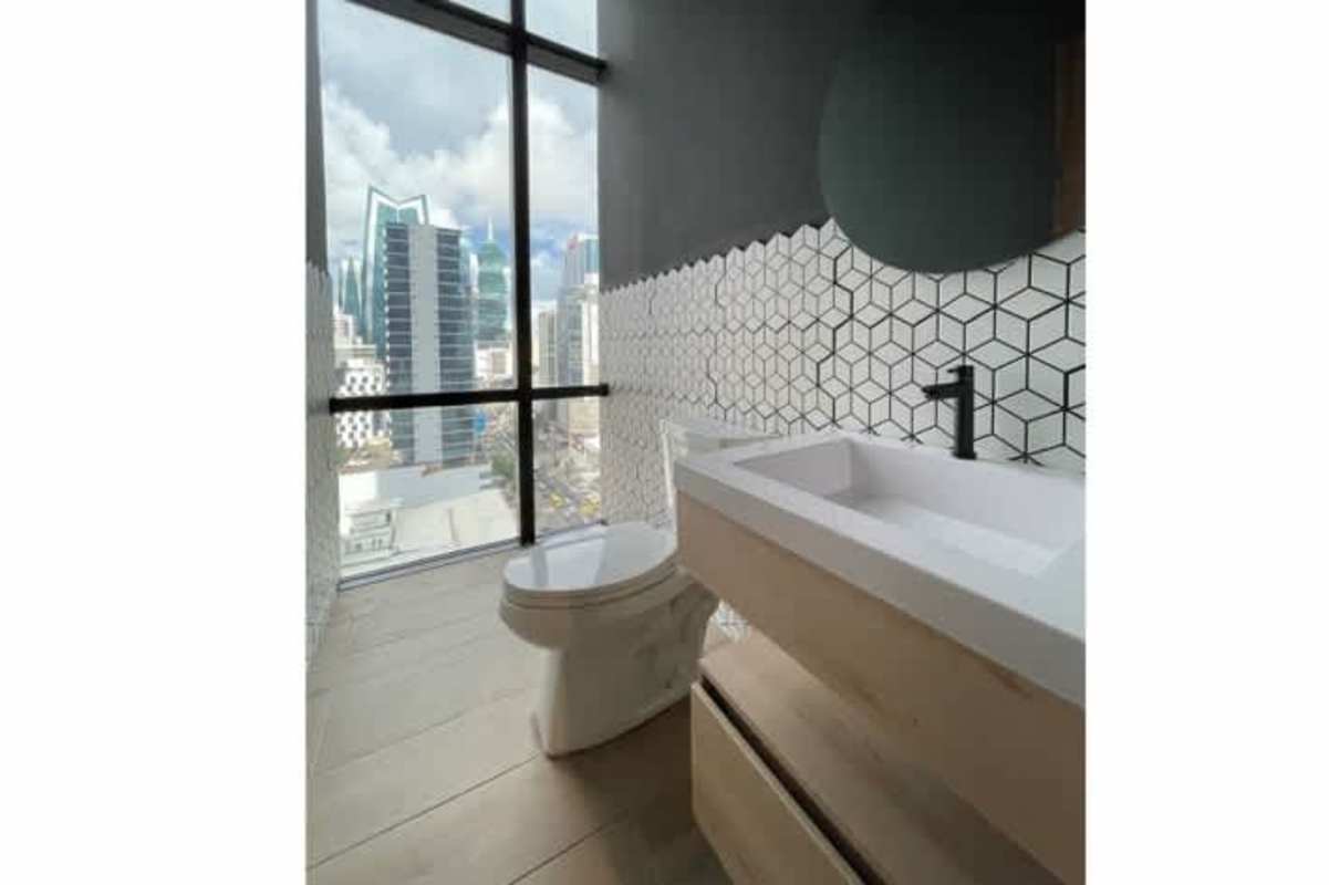 Contemporary bathroom with large window overlooking city skyline geometric tile wall vanity and light wood cabinetry at PH F&F Tower