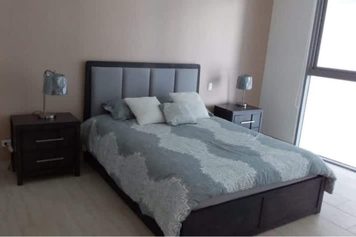 Modern living room featuring gray sofas, glass coffee table, panoramic windows in Punta Pacifica PH Oceanaire