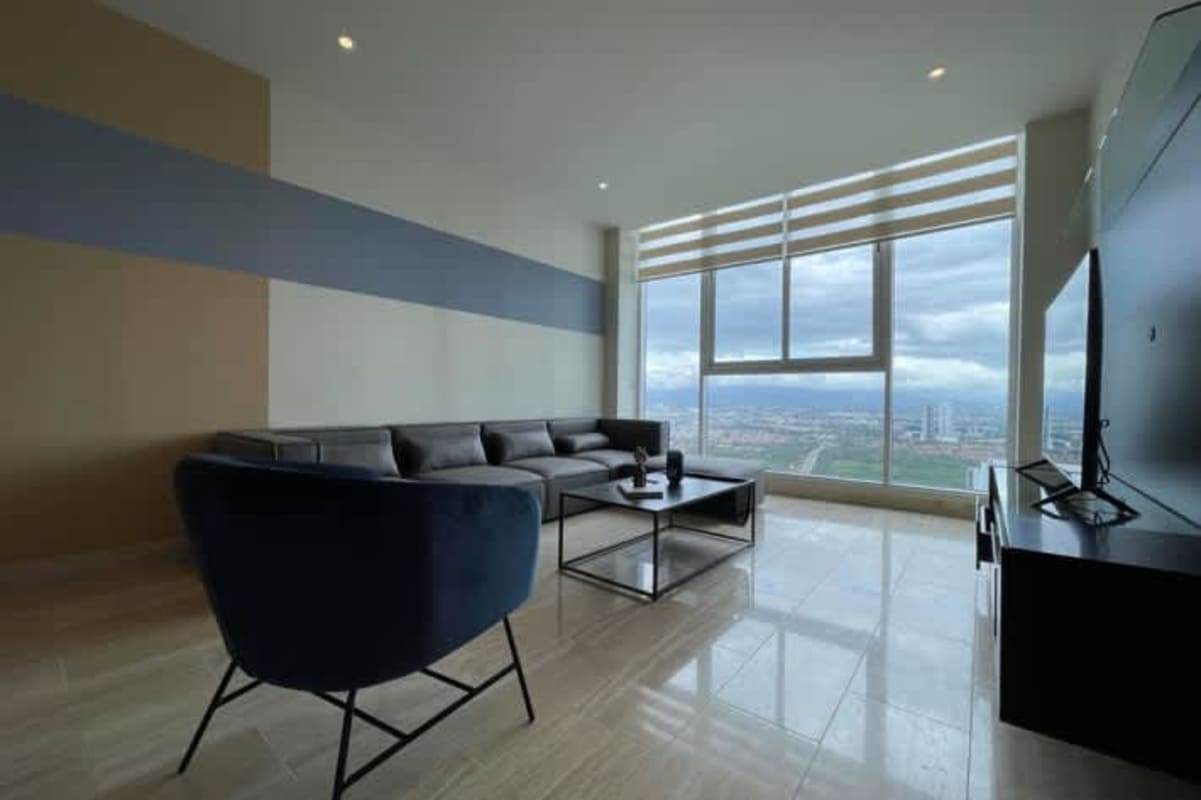 Furnished master bedroom with panoramic windows, ocean views, ensuite bathroom at PH Paramount Costa del Este Panama