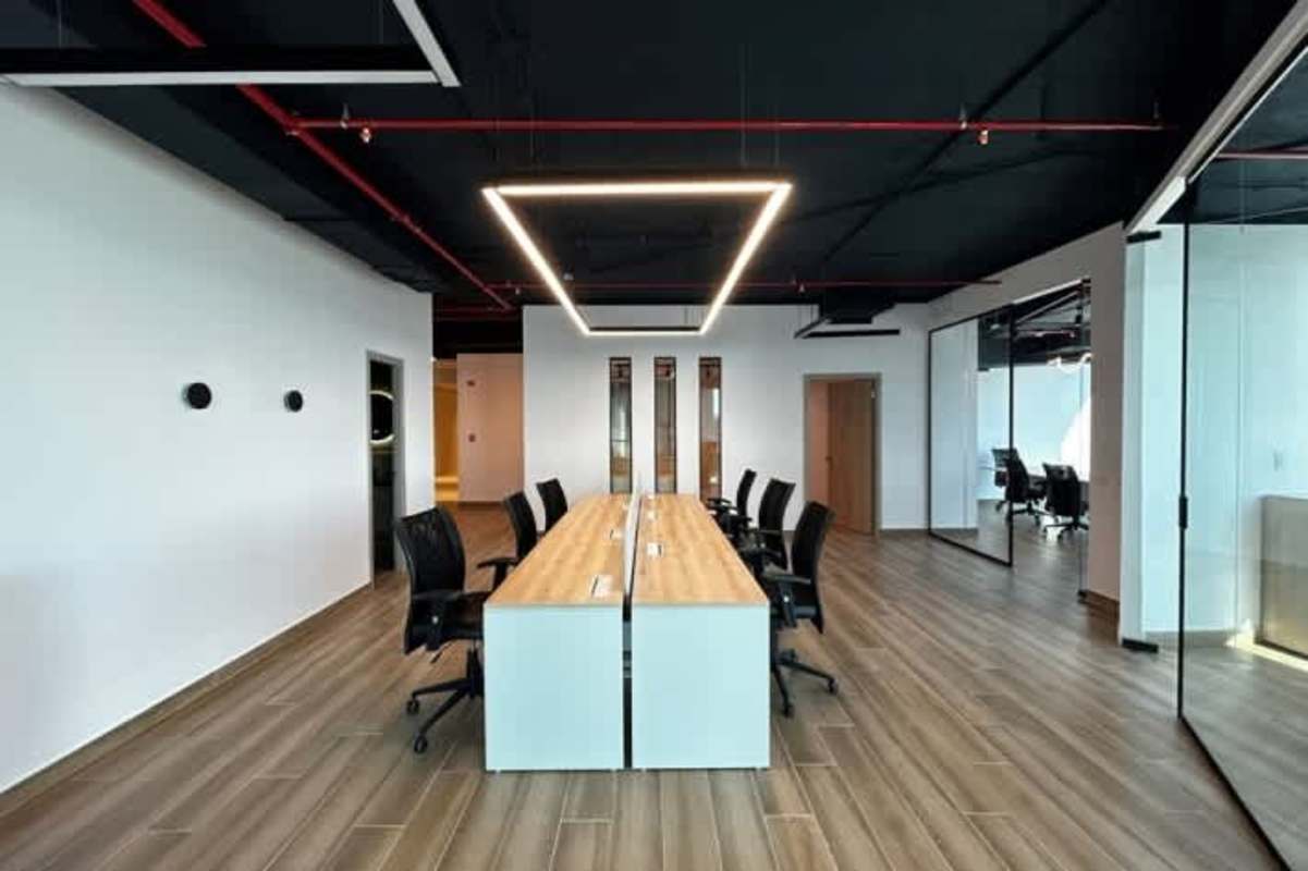 Open collaborative office with modern lighting glass partitions exposed pipes Costa del Este