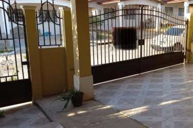 Covered patio carport area with wrought-iron gate and driveway in Brisas del Golf community Arraiján Panama