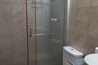 Modern bathroom with glass-enclosed shower, granite countertop and vessel sink in Panama house