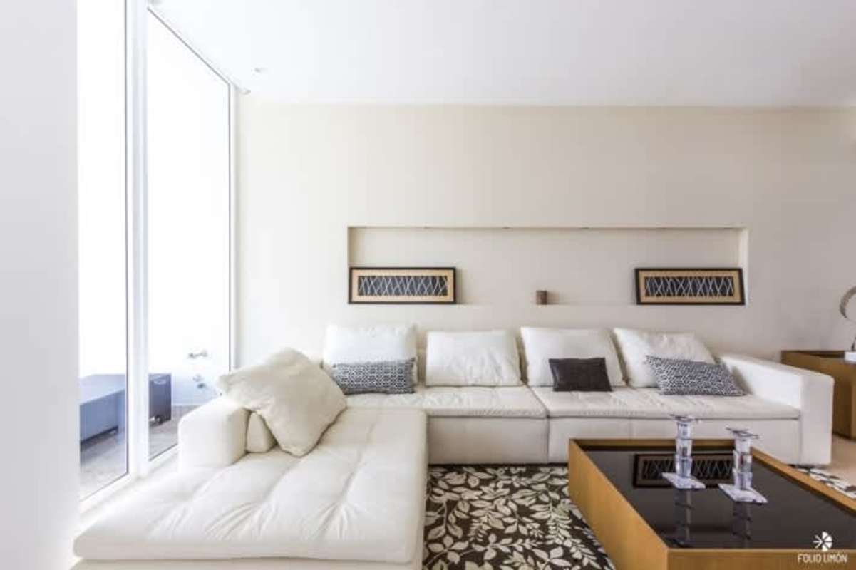 Open-plan living and dining room with ocean views, chandelier lighting at PH The Point Punta Paitilla Panama