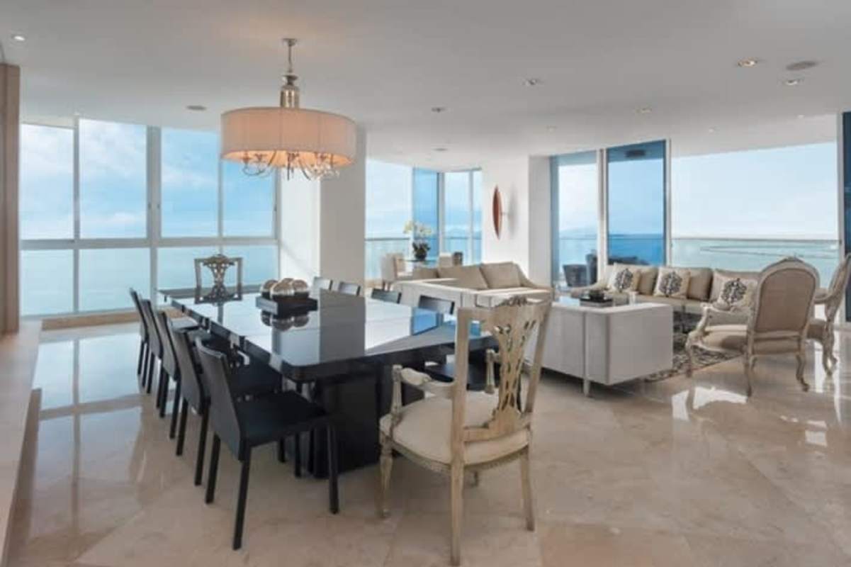 Contemporary living room with large sectional sofa, floor-to-ceiling windows, ocean and city views at PH The Point Panama