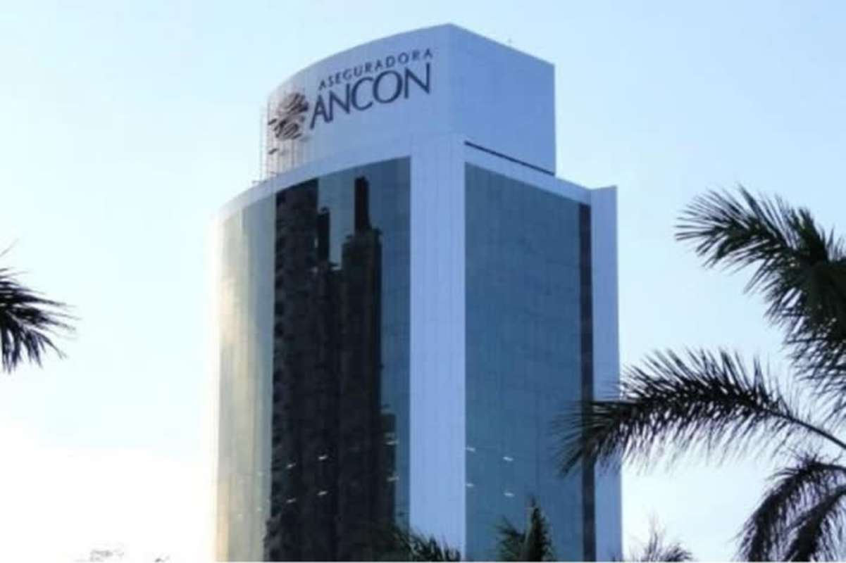 High-rise modern glass facade of Torre Aseguradora Ancón with palm trees at Costa del Este Panama City
