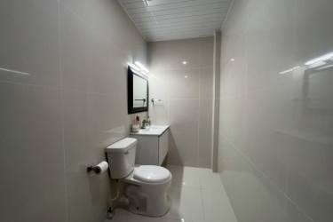 Modern bathroom with walk-in tiled shower, wall-mounted vanity, large mirror Palenque Colon Panama
