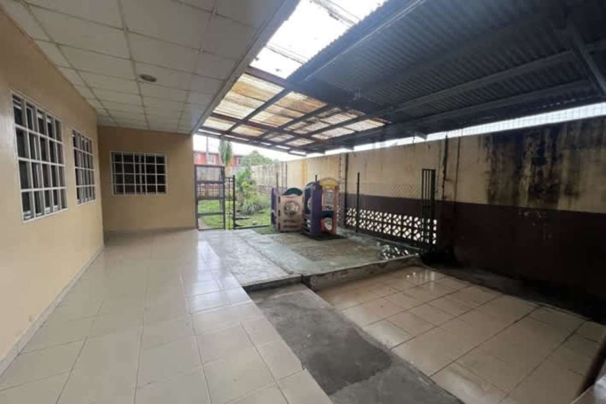 Covered hallway and child playground in fenced educational commercial building Panama City