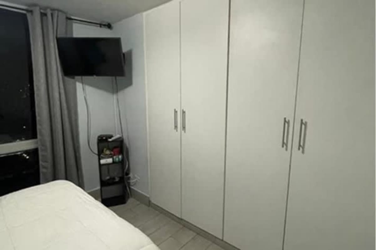 Bedroom with big white wardrobe and TV mount PH Splendor By The Park Carrasquilla Panama City
