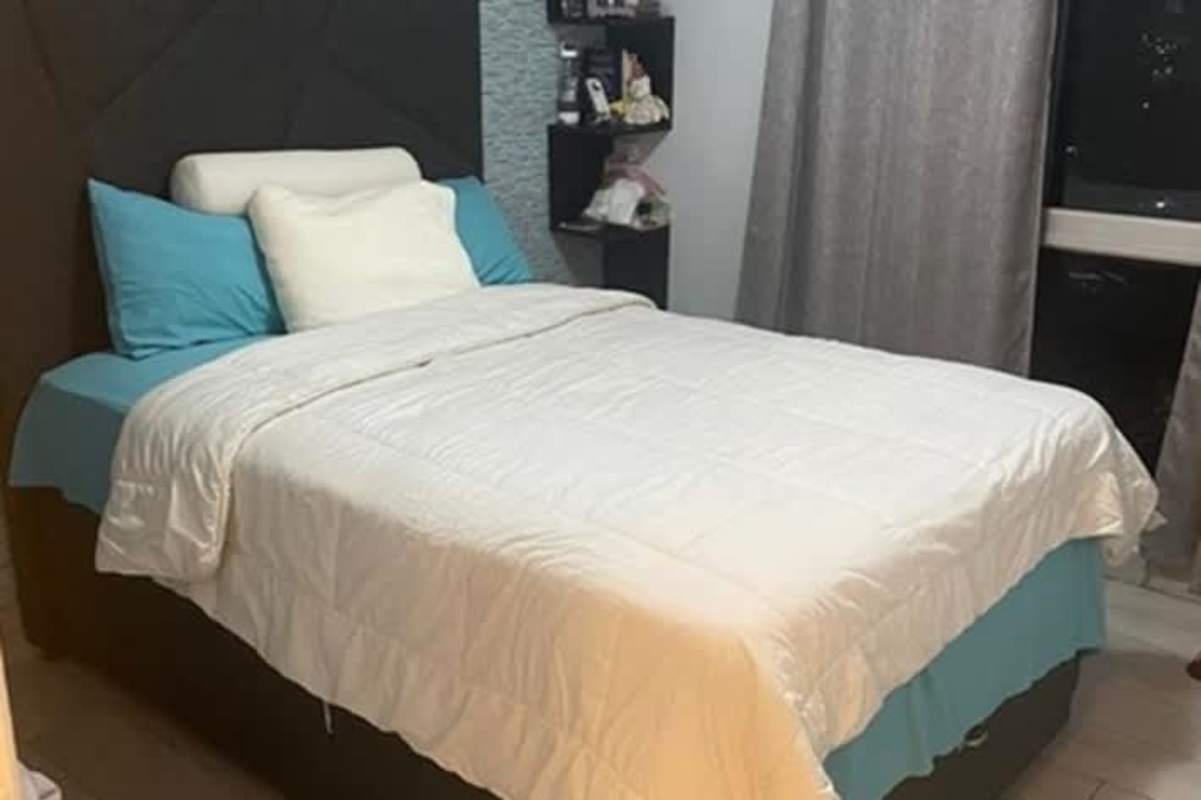 Cozy master bedroom with large window, padded headboard, and blue bedding PH Splendor By The Park Carrasquilla Panama