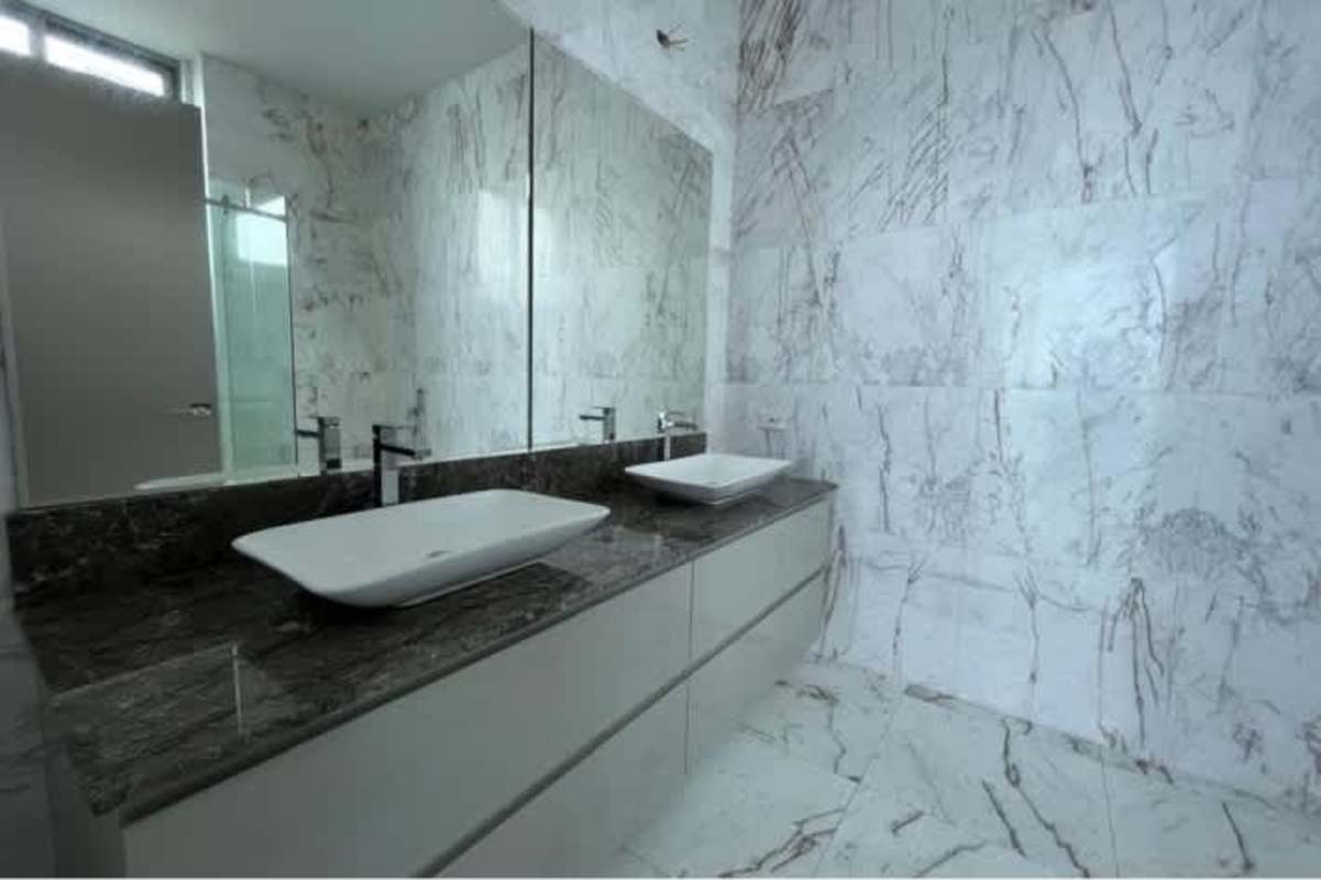 Luxury bathroom with double sinks, marble tiles, large mirror in Costa del Este penthouse
