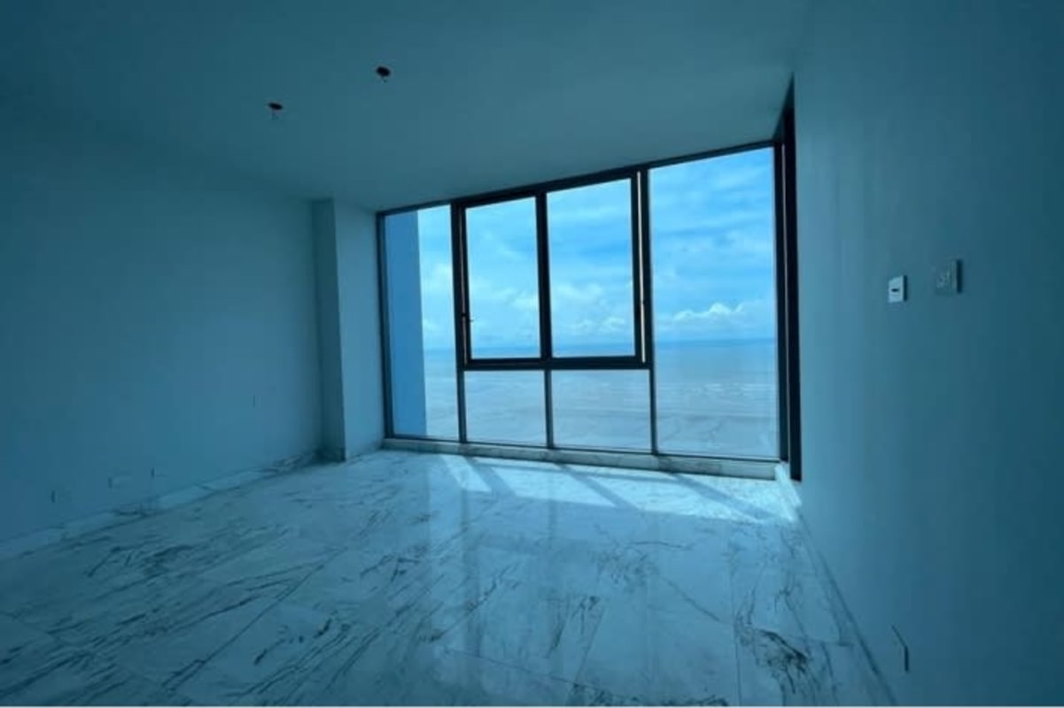 Living area with glass wall ocean views, marble floor in luxury penthouse Costa del Este