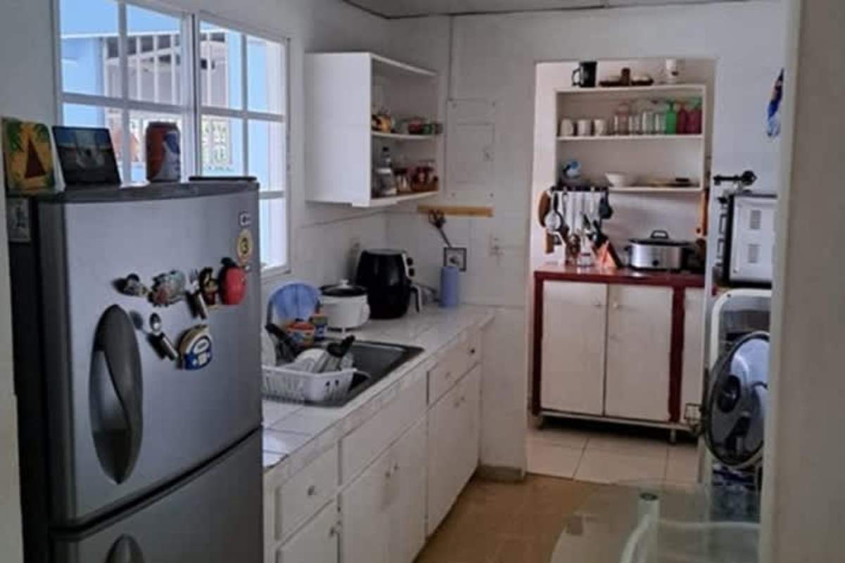 Kitchen with white cabinets, stainless steel fridge, appliances in Las Mañanitas Panama
