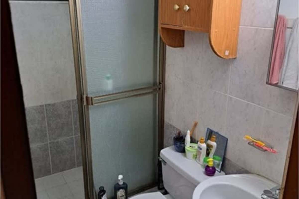 Bathroom with glass shower, wood cabinet, tile walls Las Americas Panama