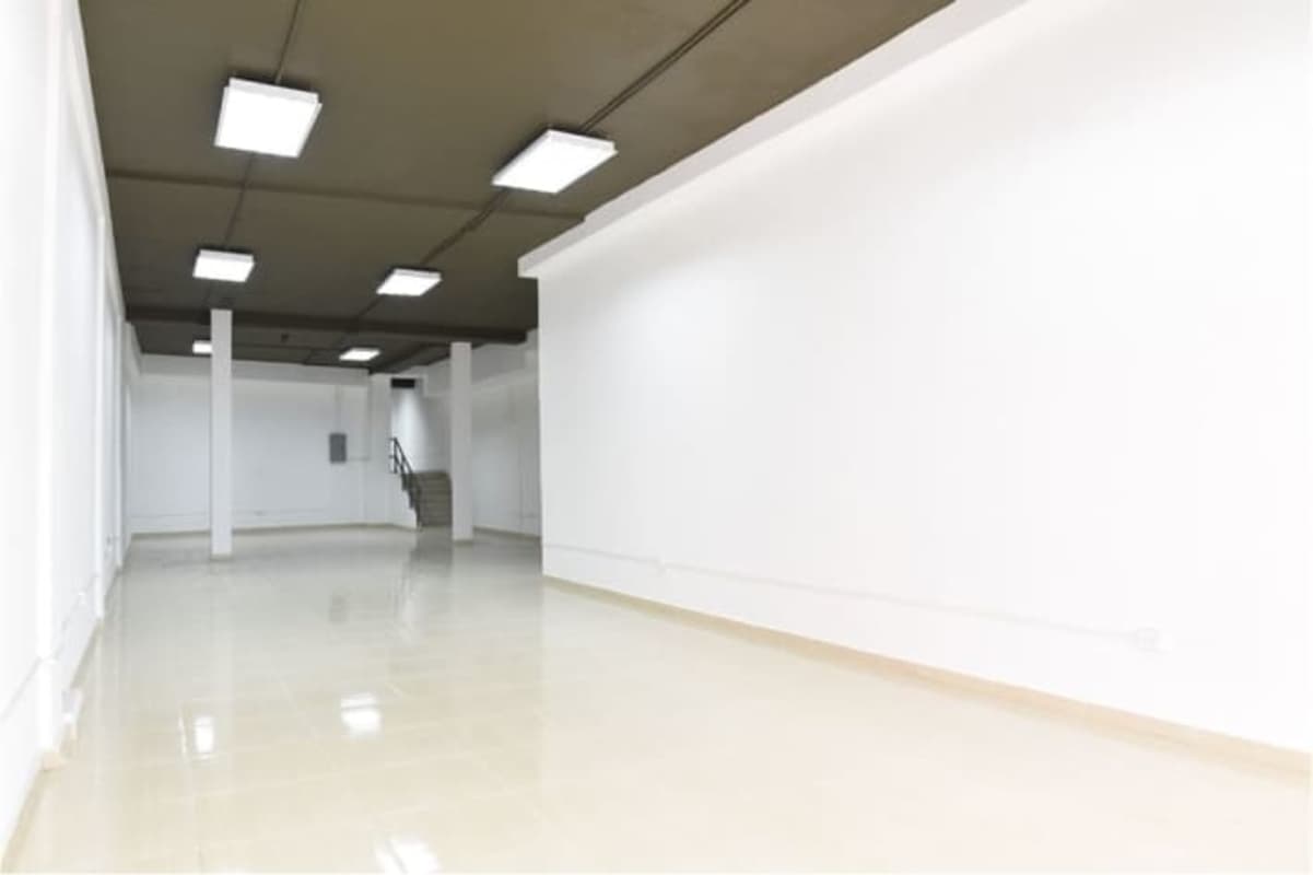 Large empty store retail interior with white walls, columns, and bright lighting in Avenida Central, Panama