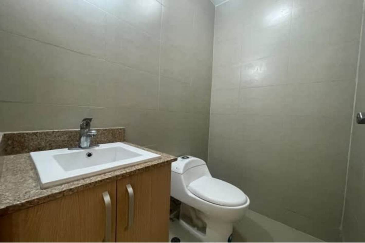 Minimalist bathroom with granite countertop and glass shower enclosure in Panama City