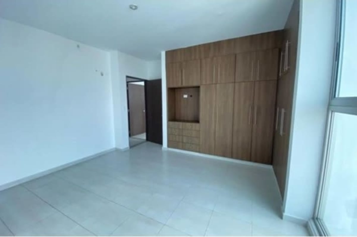 Bedroom featuring built-in wardrobe and large window with city views in PH El Cangrejo Panama