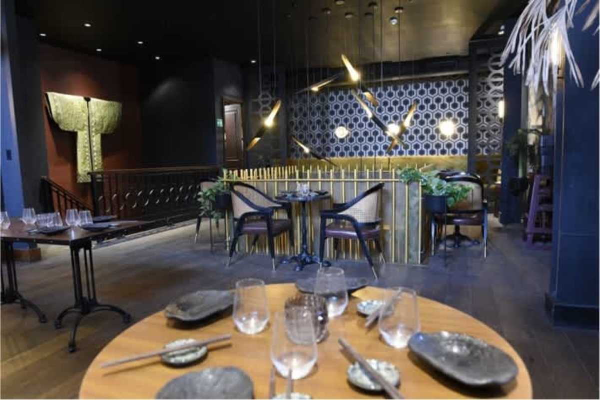 Glass elevator surrounded by exposed brick and decorative tiles in Casa Feraud Casco Viejo commercial lease